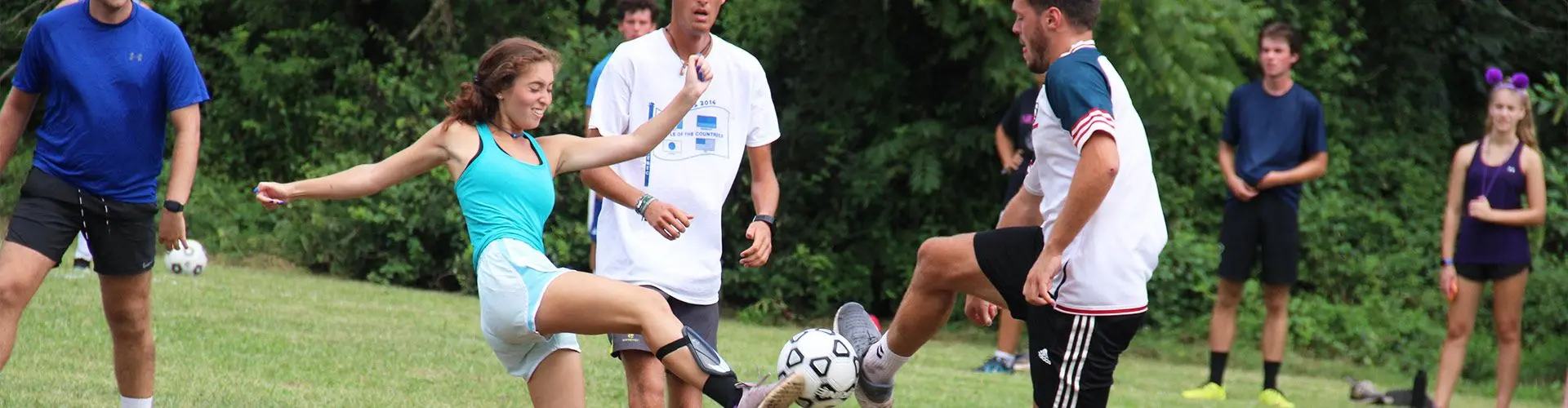 Guy and girl playing soccer on a grassy patch