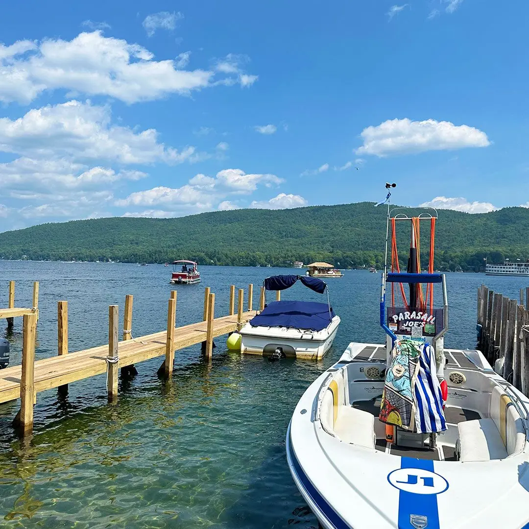 Two boats sit on the lake's harbour on a sunny day.